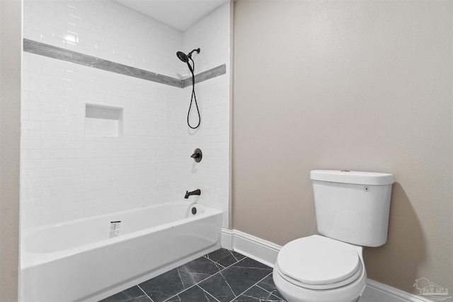 bathroom with tile patterned flooring, toilet, and tiled shower / bath