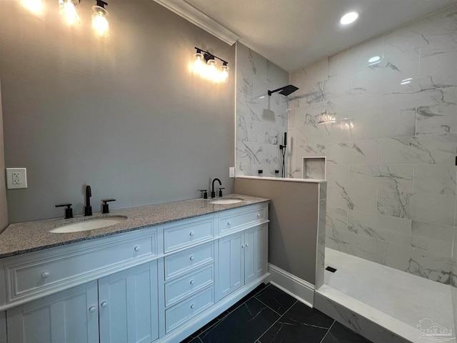 bathroom with tiled shower and vanity