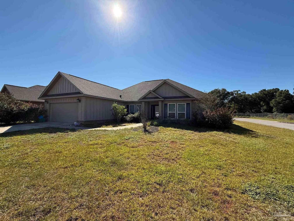 view of front of property featuring an attached garage, a front yard, and driveway
