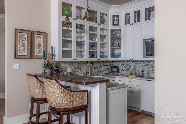 106 Matamoros Dr, Pensacola Beach, FL 32561 - bar with dark wood finished floors, a sink, and backsplash