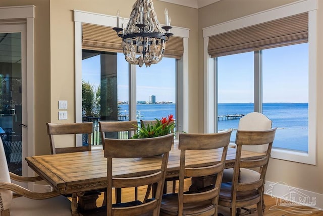 106 Matamoros Dr, Pensacola Beach, FL 32561 - dining area featuring baseboards, a water view, and a chandelier