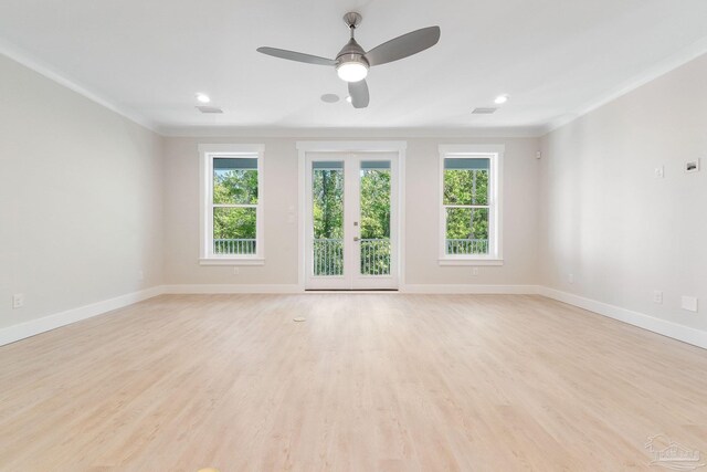 spare room featuring crown molding, light wood-type flooring, ceiling fan, and a wealth of natural light