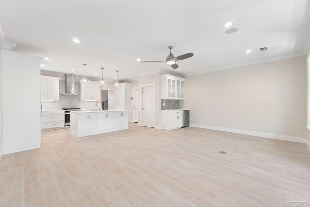 unfurnished living room with light hardwood / wood-style floors, sink, ceiling fan, and beverage cooler