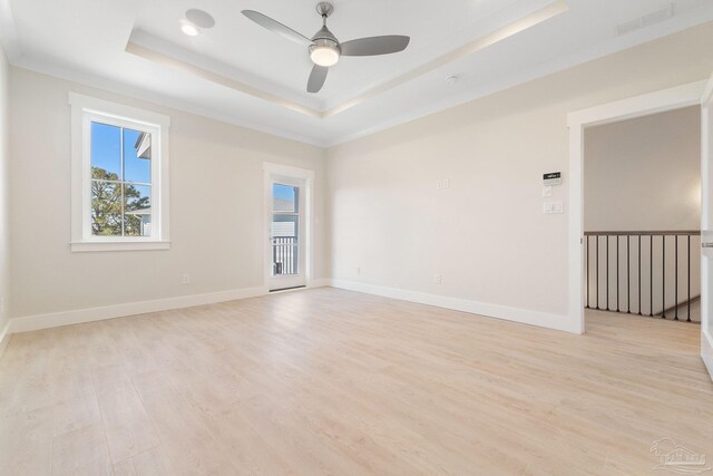 unfurnished room featuring light hardwood / wood-style flooring, ceiling fan, and a tray ceiling