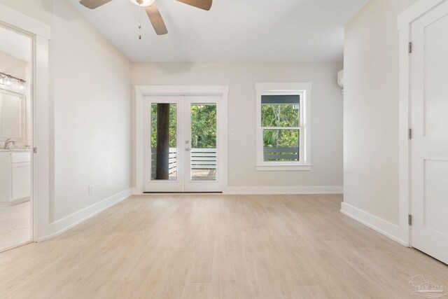 unfurnished room with sink, light hardwood / wood-style flooring, ceiling fan, and french doors