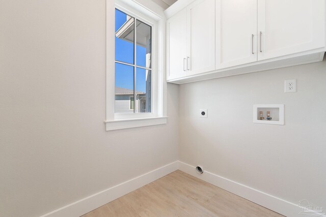 laundry room with light hardwood / wood-style floors, cabinets, electric dryer hookup, and washer hookup