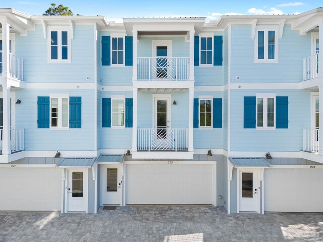 view of property featuring a garage and a balcony