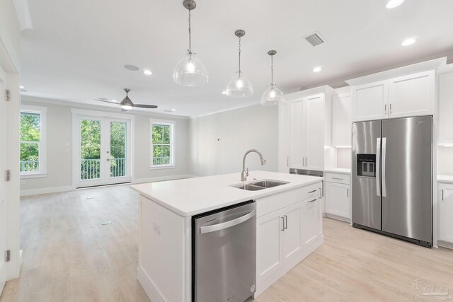 kitchen with sink, light wood-type flooring, stainless steel appliances, and an island with sink