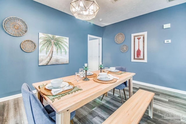 dining room featuring a notable chandelier and hardwood / wood-style flooring