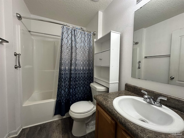 bathroom featuring a textured ceiling, wood finished floors, toilet, shower / bath combo with shower curtain, and vanity