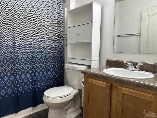 bathroom with toilet, vanity, and curtained shower