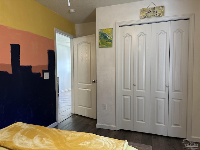 bedroom featuring a closet, dark wood finished floors, and baseboards
