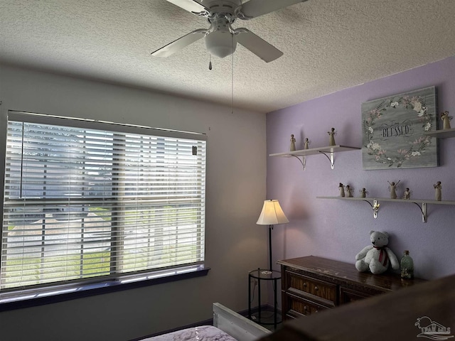 bedroom with a textured ceiling and ceiling fan