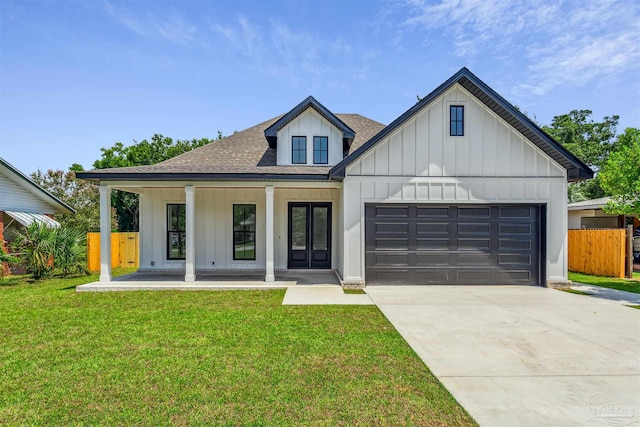 modern inspired farmhouse with a garage, covered porch, and a front yard