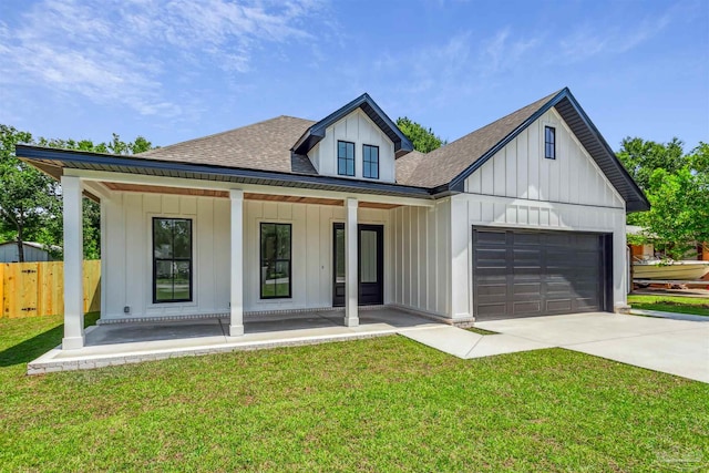 view of front of property with a garage, a front lawn, and covered porch