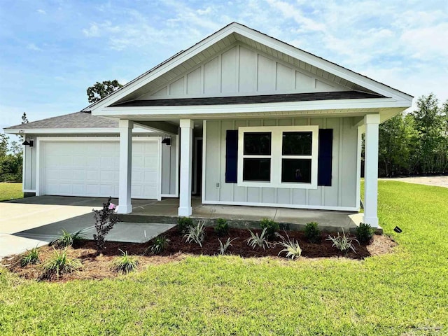 view of front of property with a front yard, covered porch, and a garage