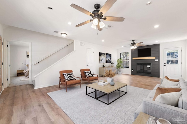 living area featuring stairway, plenty of natural light, visible vents, and light wood-type flooring