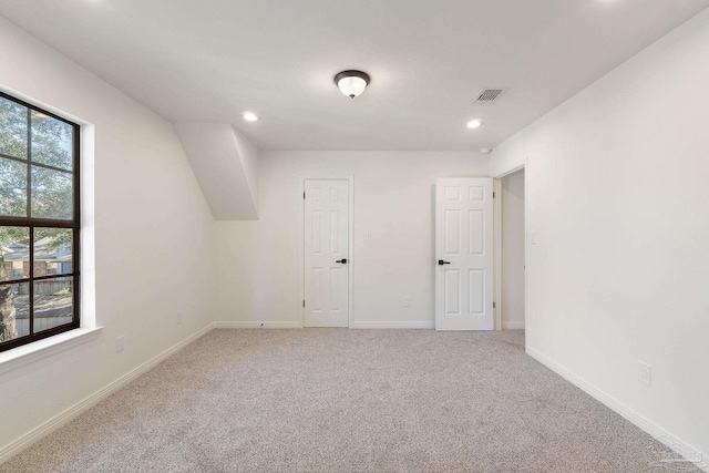 spare room with recessed lighting, visible vents, baseboards, and light carpet