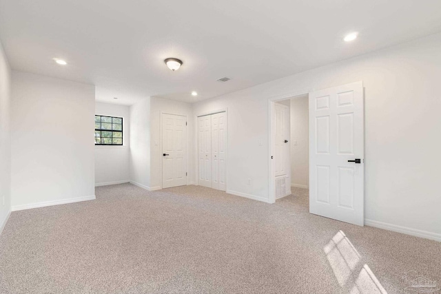 unfurnished room with light carpet, visible vents, and baseboards