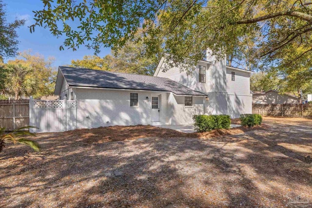 back of property with brick siding and fence