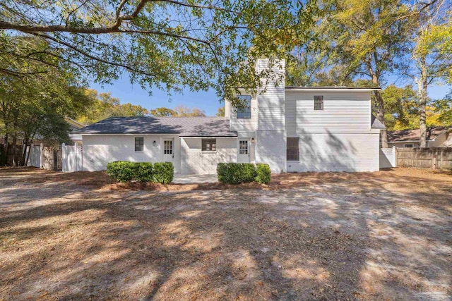 back of property with brick siding and fence