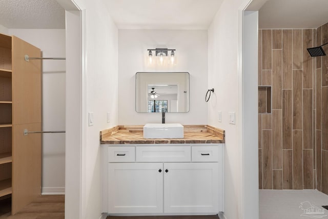 full bath with vanity and tiled shower