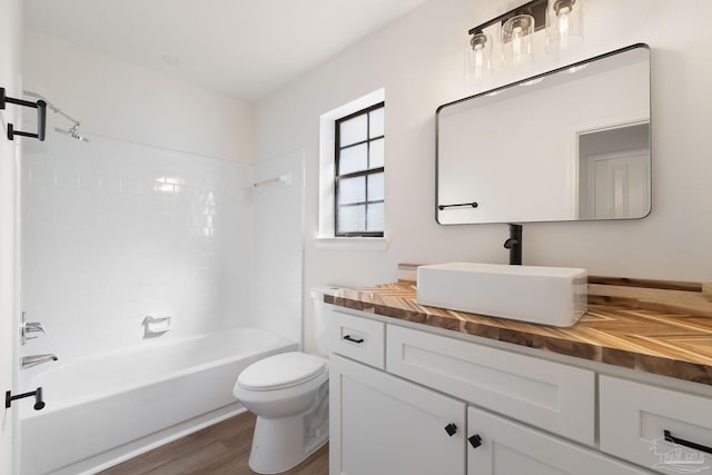 full bathroom featuring wood finished floors, toilet, bathtub / shower combination, and vanity