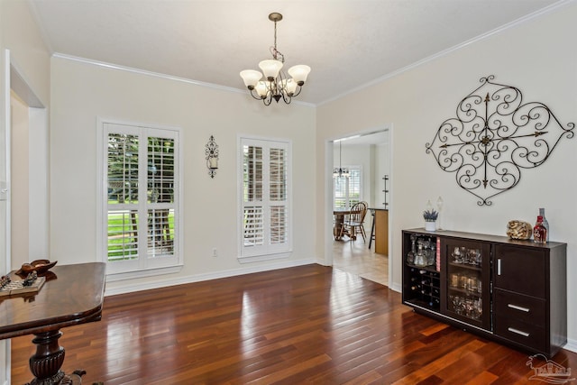 dining area featuring baseboards, a chandelier, hardwood / wood-style floors, and ornamental molding