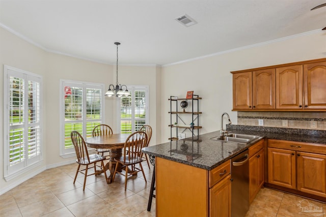 kitchen with a peninsula, a sink, visible vents, decorative backsplash, and brown cabinetry