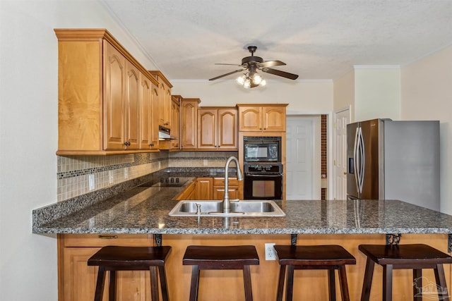 kitchen with crown molding, decorative backsplash, a sink, a peninsula, and black appliances