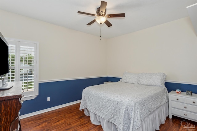 bedroom featuring ceiling fan, baseboards, and wood finished floors