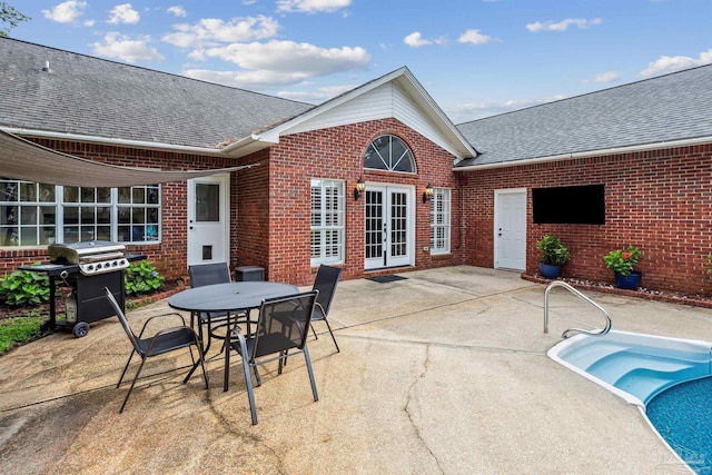 view of patio / terrace with french doors, a grill, and an outdoor pool