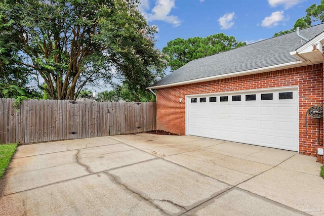 garage with driveway and fence