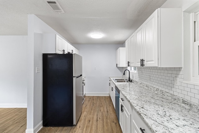 kitchen with white cabinetry, sink, tasteful backsplash, and stainless steel appliances