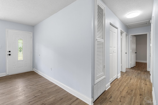 entryway with light hardwood / wood-style floors and a textured ceiling