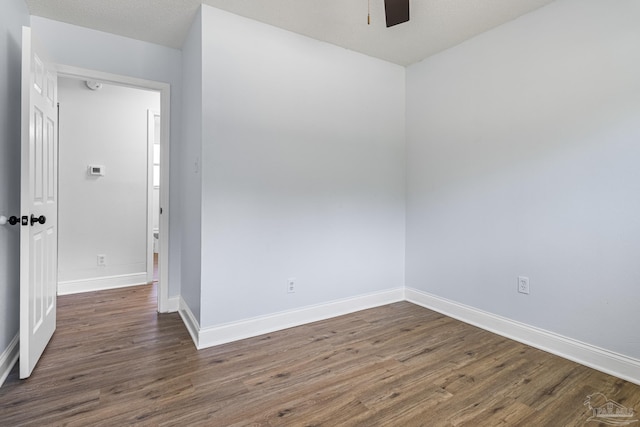 spare room with ceiling fan, a textured ceiling, and dark hardwood / wood-style flooring