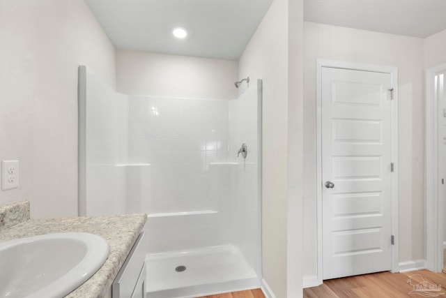 bathroom with walk in shower, wood-type flooring, and vanity