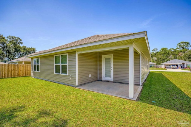 rear view of house featuring a lawn and a patio area