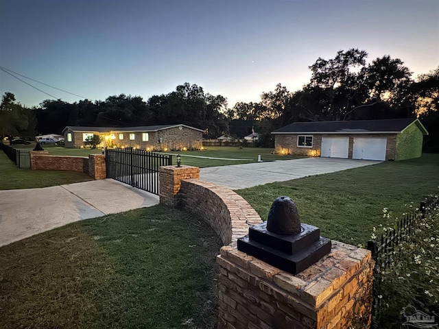 yard at dusk featuring an outbuilding and a garage