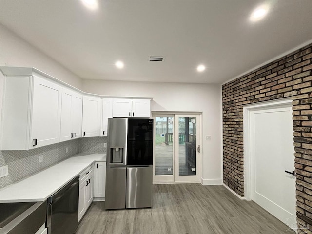 kitchen featuring dishwasher, stainless steel fridge, white cabinets, and hardwood / wood-style floors