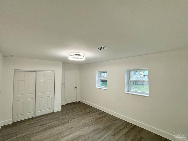 unfurnished bedroom featuring a closet and dark wood-type flooring