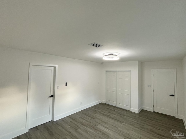 unfurnished bedroom with dark wood-type flooring