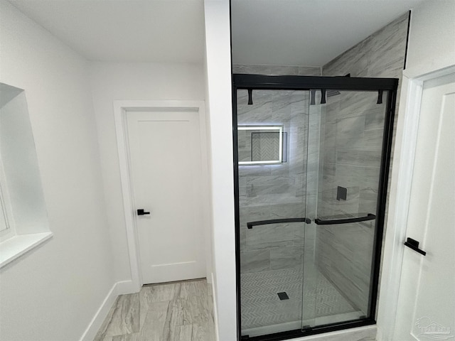 bathroom with a shower with door