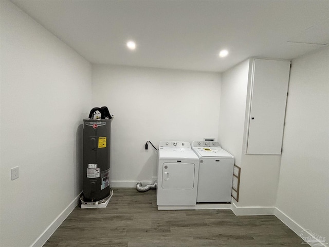 laundry room featuring washer and dryer, dark wood-type flooring, and water heater