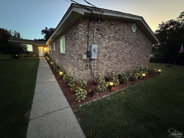 property exterior at dusk with a yard