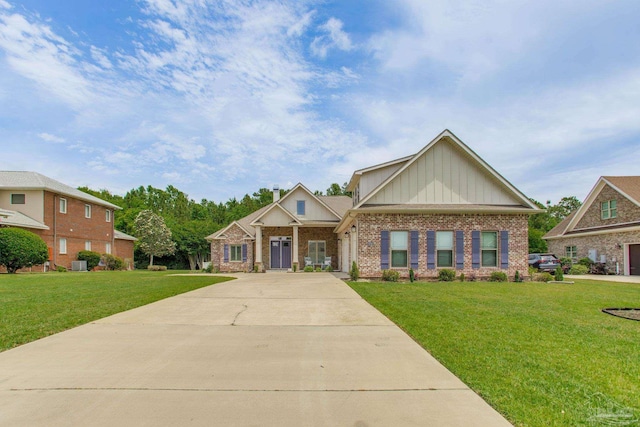 craftsman-style house featuring board and batten siding, a front yard, brick siding, and concrete driveway