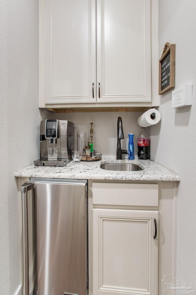 bar featuring fridge and a sink