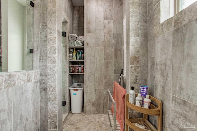 bathroom with tile walls and walk in shower