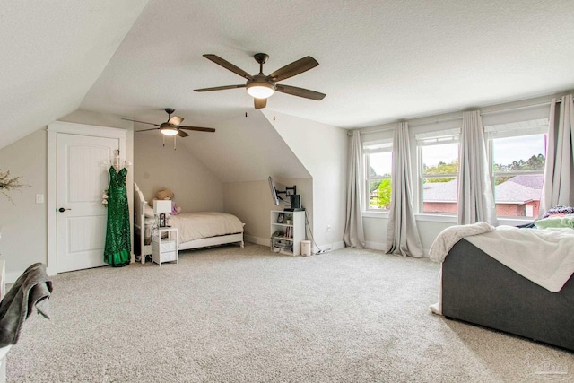 carpeted bedroom with lofted ceiling, a textured ceiling, and a ceiling fan