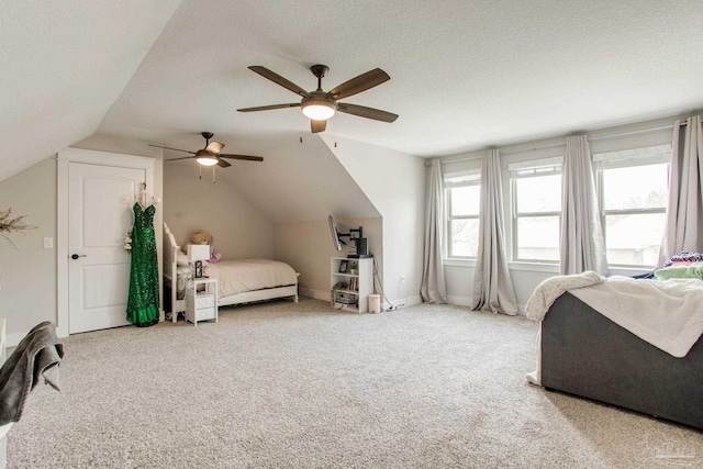 bedroom with vaulted ceiling, carpet floors, a textured ceiling, and a ceiling fan